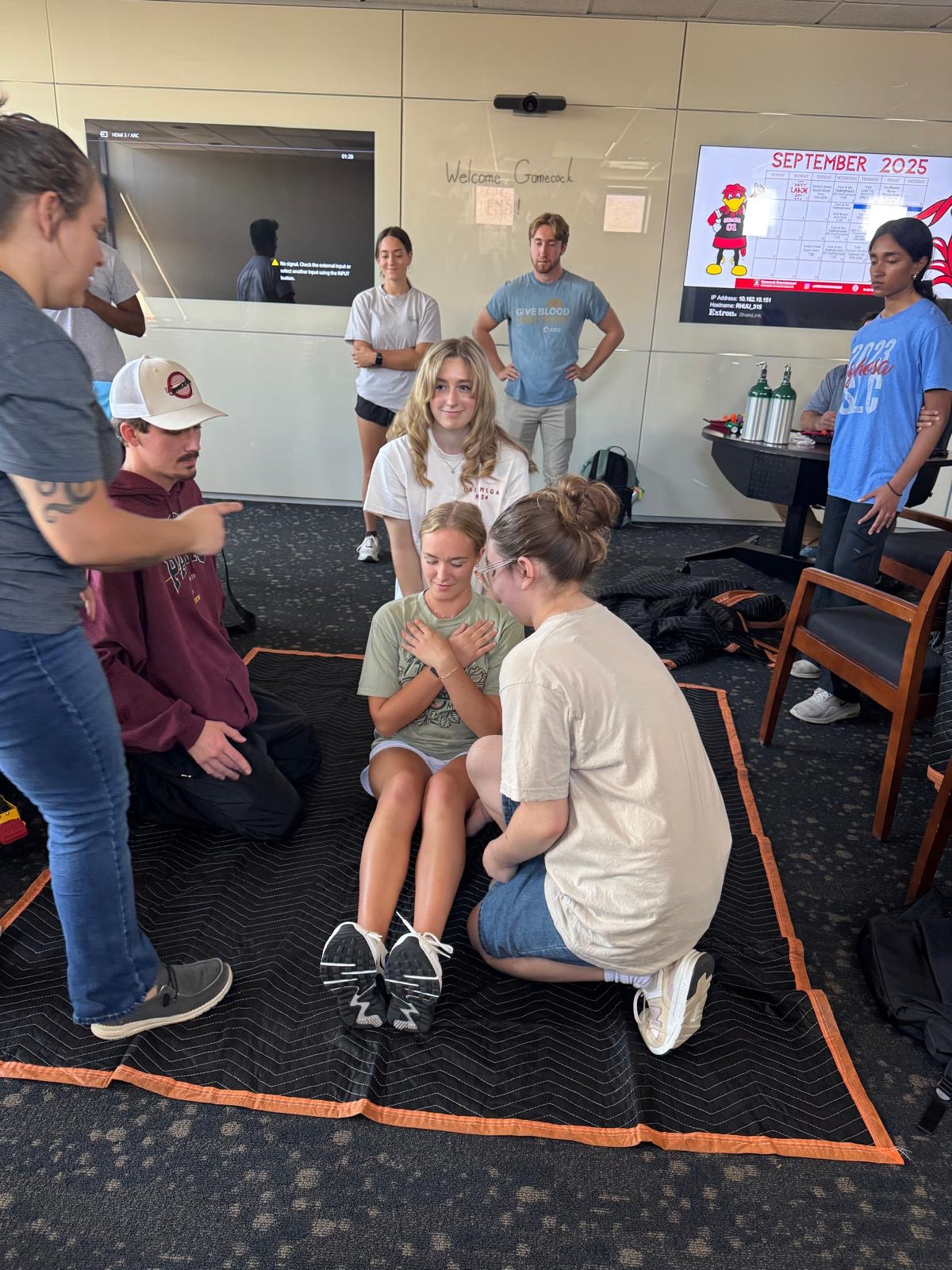 Members assessing a seated patient during a hands-on skills session